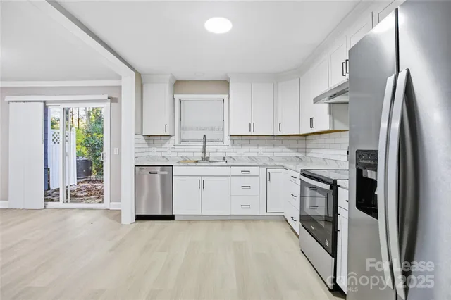 a kitchen with stainless steel appliances granite countertop a refrigerator sink and stove