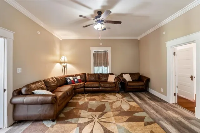 a living room with furniture and a ceiling fan