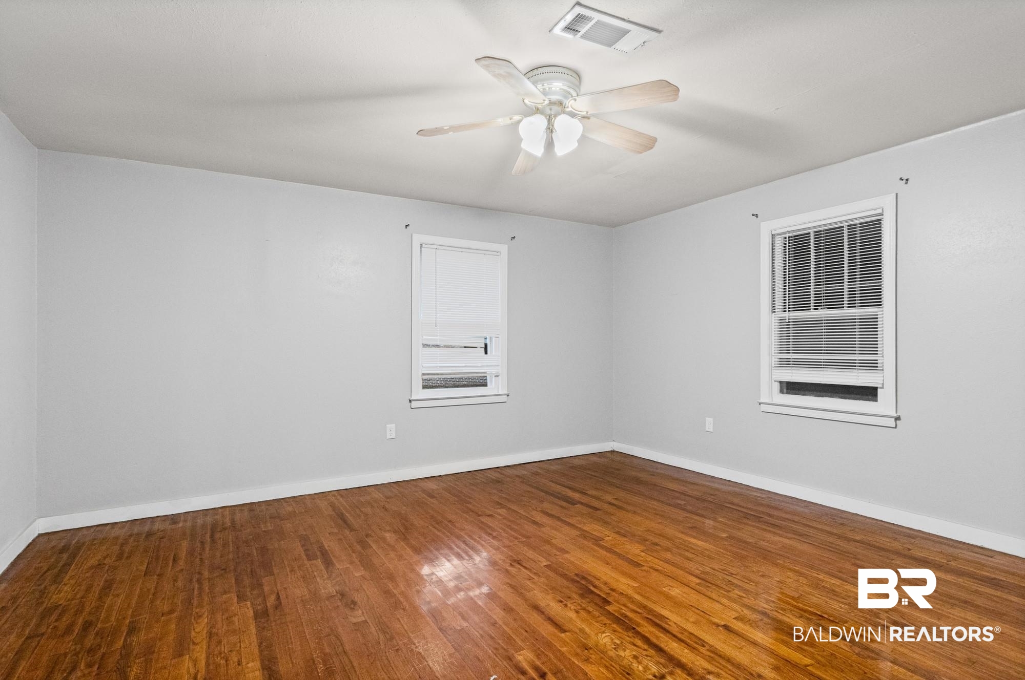 312 Sutherland Drive Mobile, AL 36611 - Photo 19 of 28 Unfurnished bedroom featuring wood-finish flooring, light gray walls, and white baseboards