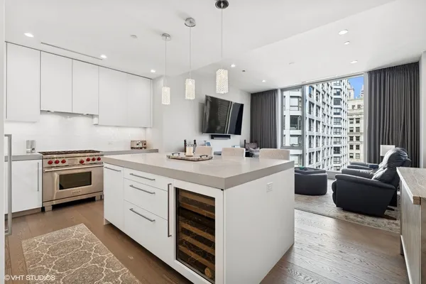 a living room with furniture and a dining table with kitchen appliances