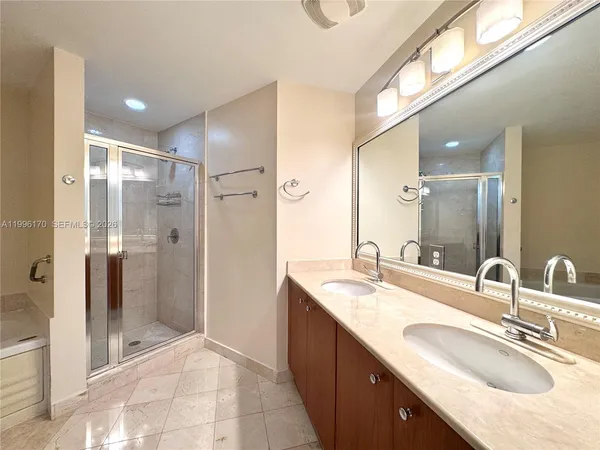 a bathroom with a granite countertop sink mirror and shower