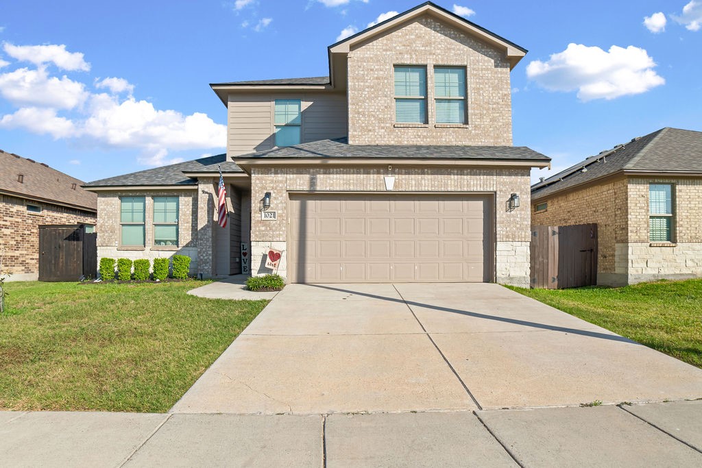 a front view of a house with a yard and garage