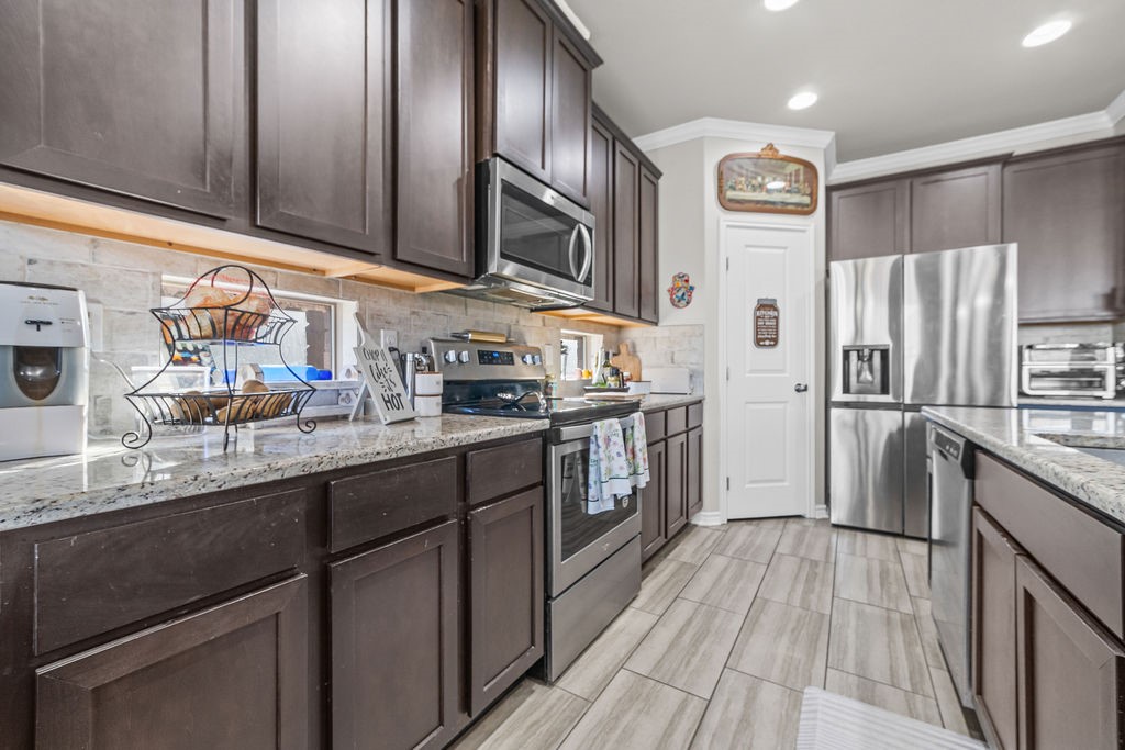 1021 Pasadena Street Portland, TX 78374 - Photo 12 of 37 a kitchen with stainless steel appliances granite countertop a refrigerator a stove top oven and sink