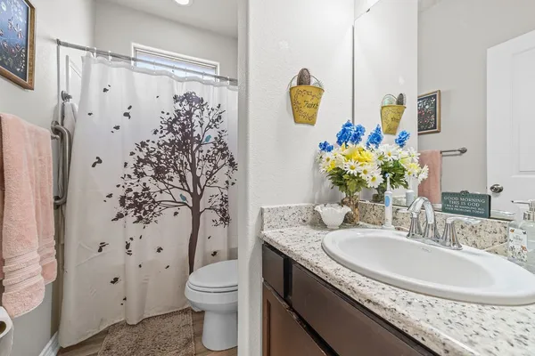 a bathroom with a granite countertop sink a toilet and bathtub