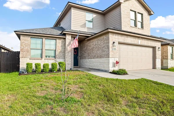 a front view of a house with a yard and garage