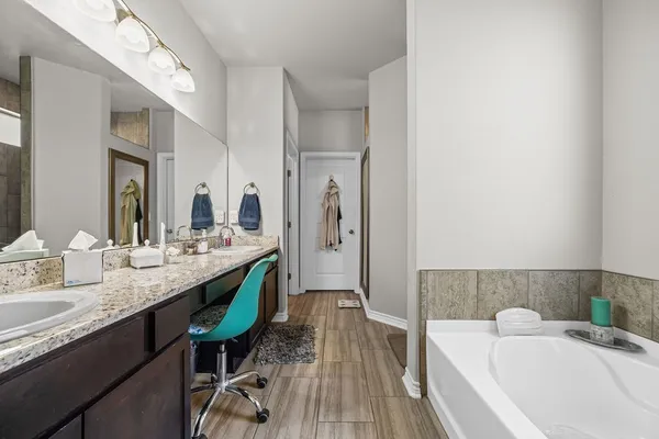 a bathroom with a tub and a view of living room