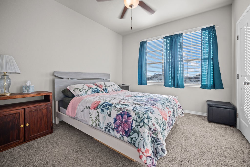 1021 Pasadena Street Portland, TX 78374 - Photo 32 of 37 a bedroom with a large bed and a chandelier