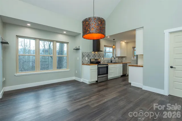 a kitchen with stainless steel appliances granite countertop a stove a sink and a wooden floors