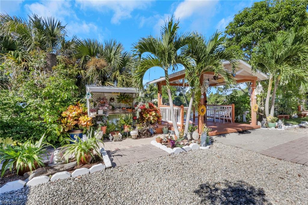 4983 18th Court Southwest Naples, FL 34116 - Photo 11 of 37 a view of a road with potted plants and large trees