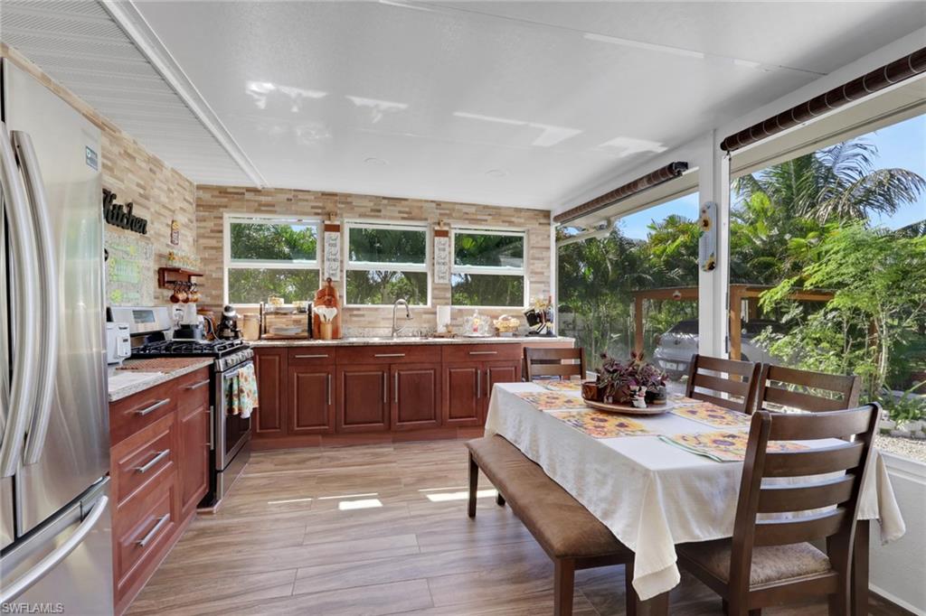 4983 18th Court Southwest Naples, FL 34116 - Photo 22 of 37 a kitchen with a table chairs stove and refrigerator
