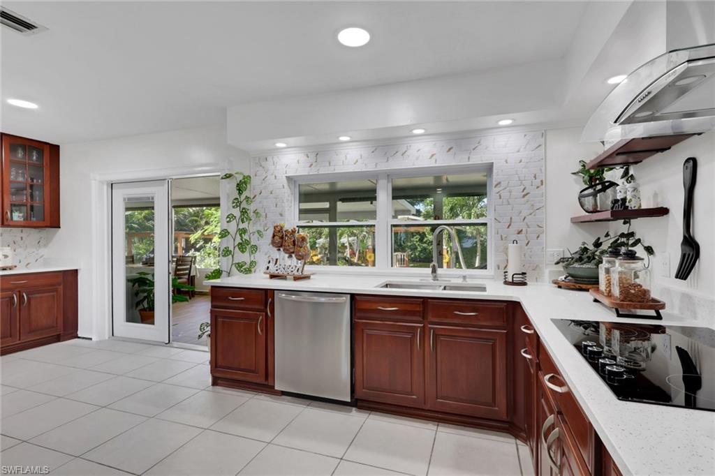 4983 18th Court Southwest Naples, FL 34116 - Photo 23 of 37 a kitchen with stainless steel appliances granite countertop a stove a sink and a microwave