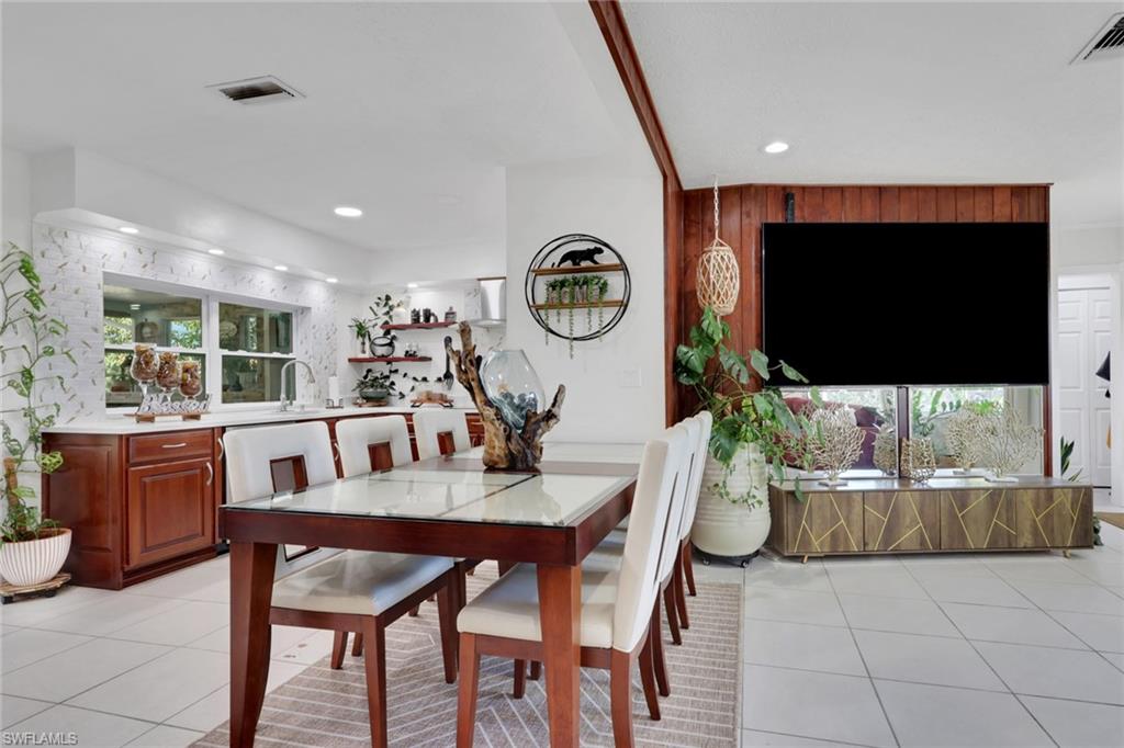 4983 18th Court Southwest Naples, FL 34116 - Photo 29 of 37 a dining room with furniture and a flat screen tv