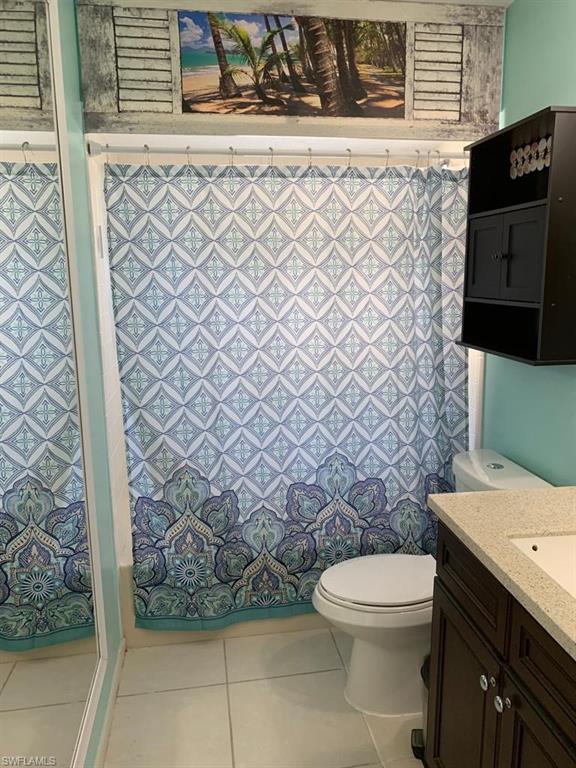 4983 18th Court Southwest Naples, FL 34116 - Photo 34 of 37 a bathroom with a toilet and a shower curtain