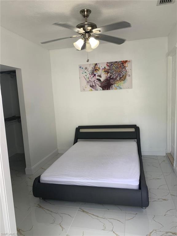 4983 18th Court Southwest Naples, FL 34116 - Photo 37 of 37 a bedroom with a bed and a chandelier