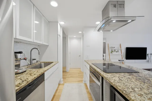 a kitchen with granite countertop a sink and a stove
