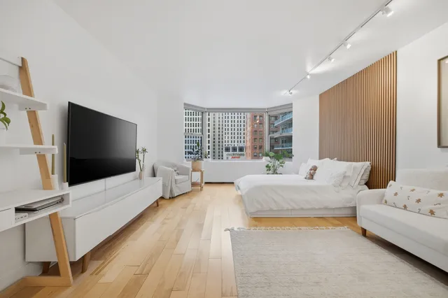 a spacious bedroom with a bed and a flat screen tv