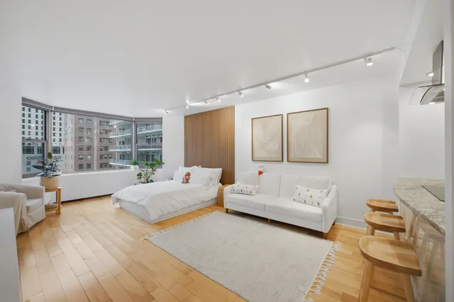 a spacious bedroom with a bed and glass window