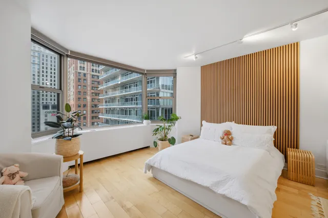 a bedroom with furniture and a large window