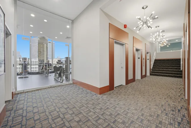 a view of a hallway with dining area and chandelier