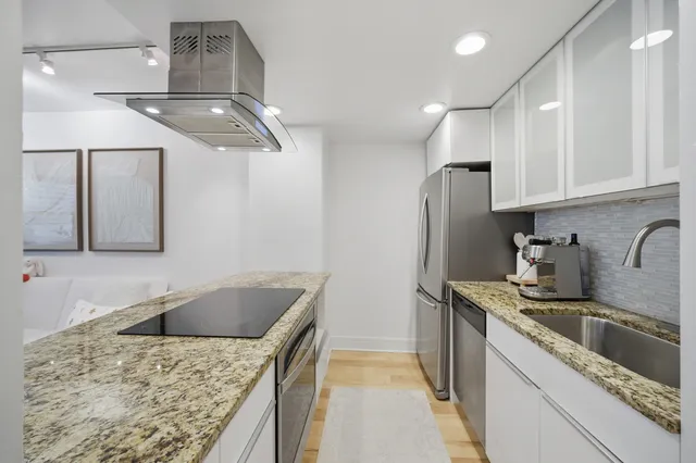 a kitchen with stainless steel appliances granite countertop a sink a stove and refrigerator