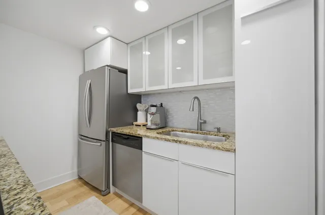 a kitchen with stainless steel appliances granite countertop a refrigerator and a sink