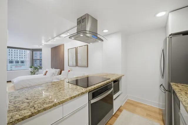 a kitchen with granite countertop stainless steel appliances a sink stove and refrigerator