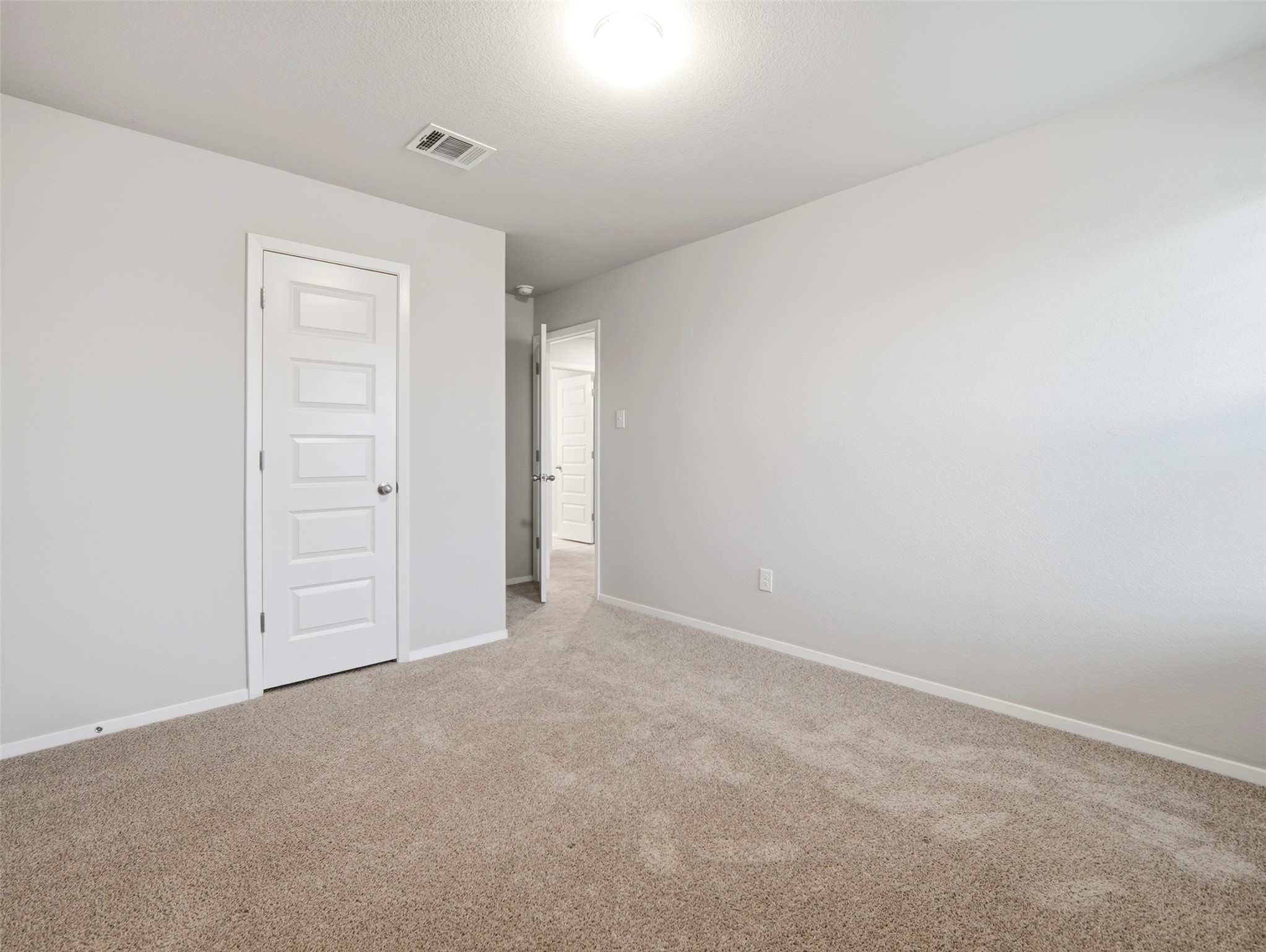 60 Bent Trl Lane Georgetown, TX 78628 - Photo 21 of 40 A well-lit bedroom features plush carpeting and classic paneled doors, offering a fresh, inviting retreat.