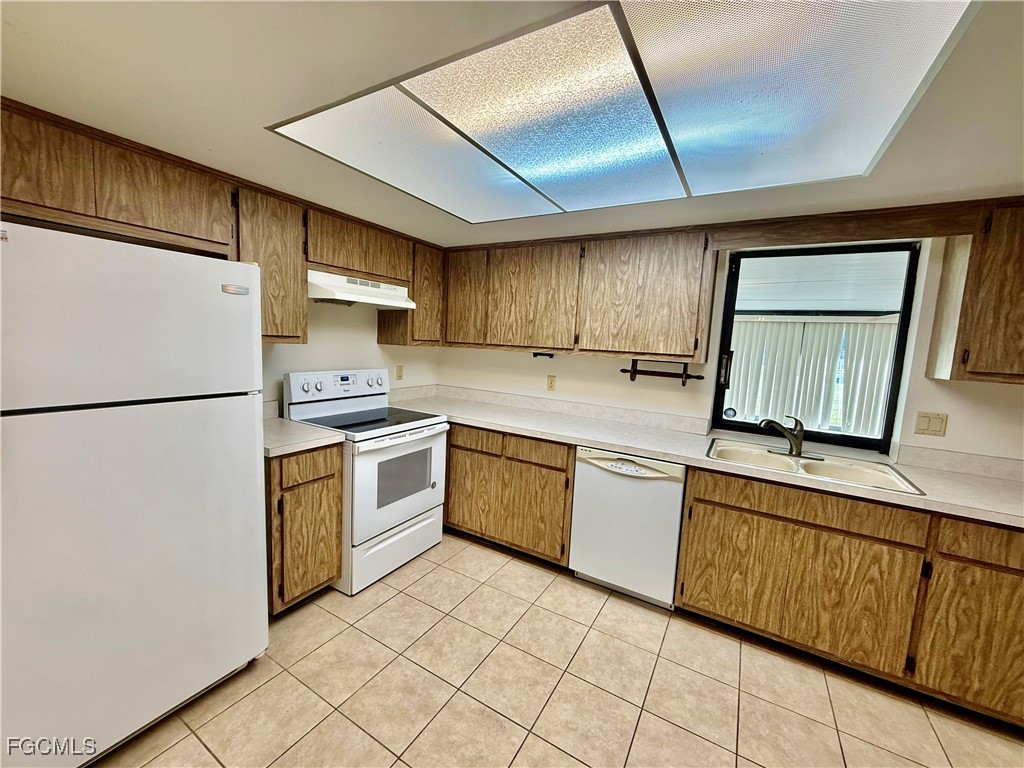 24 Clayton Avenue Lehigh Acres, FL 33936 - Photo 12 of 28 a kitchen with a refrigerator sink and cabinets