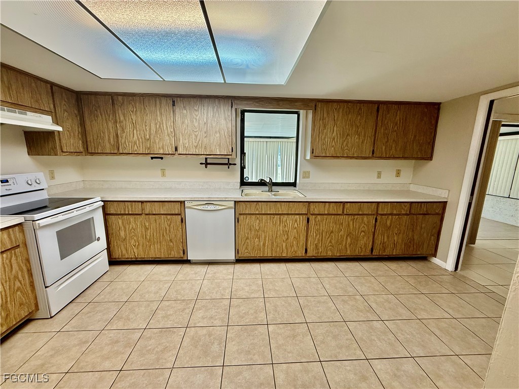 24 Clayton Avenue Lehigh Acres, FL 33936 - Photo 13 of 28 a kitchen with a sink a stove top oven and cabinets