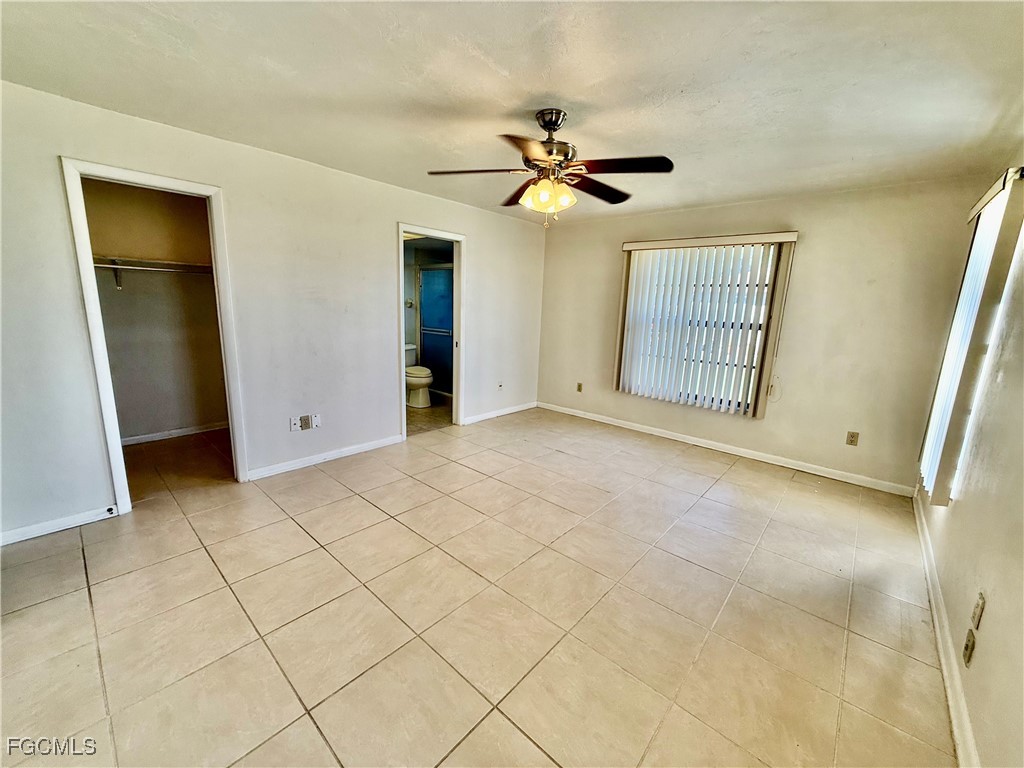 24 Clayton Avenue Lehigh Acres, FL 33936 - Photo 18 of 28 a view of a livingroom with a chandelier fan and windows