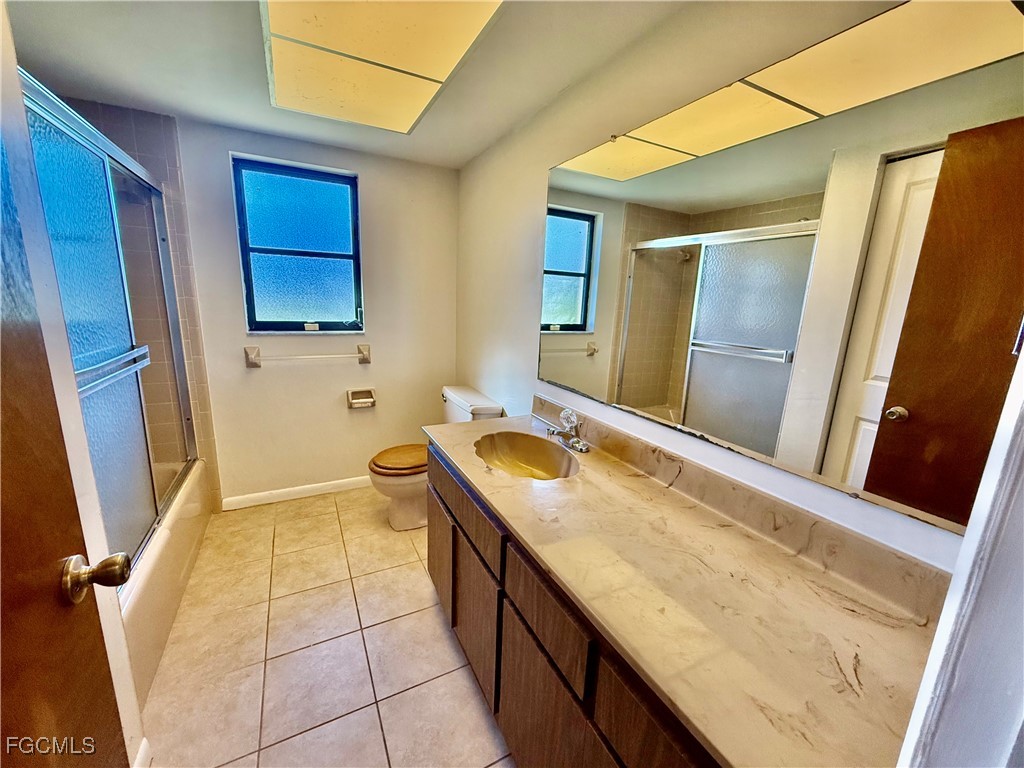 24 Clayton Avenue Lehigh Acres, FL 33936 - Photo 22 of 28 a bathroom with a granite countertop sink a toilet and mirror