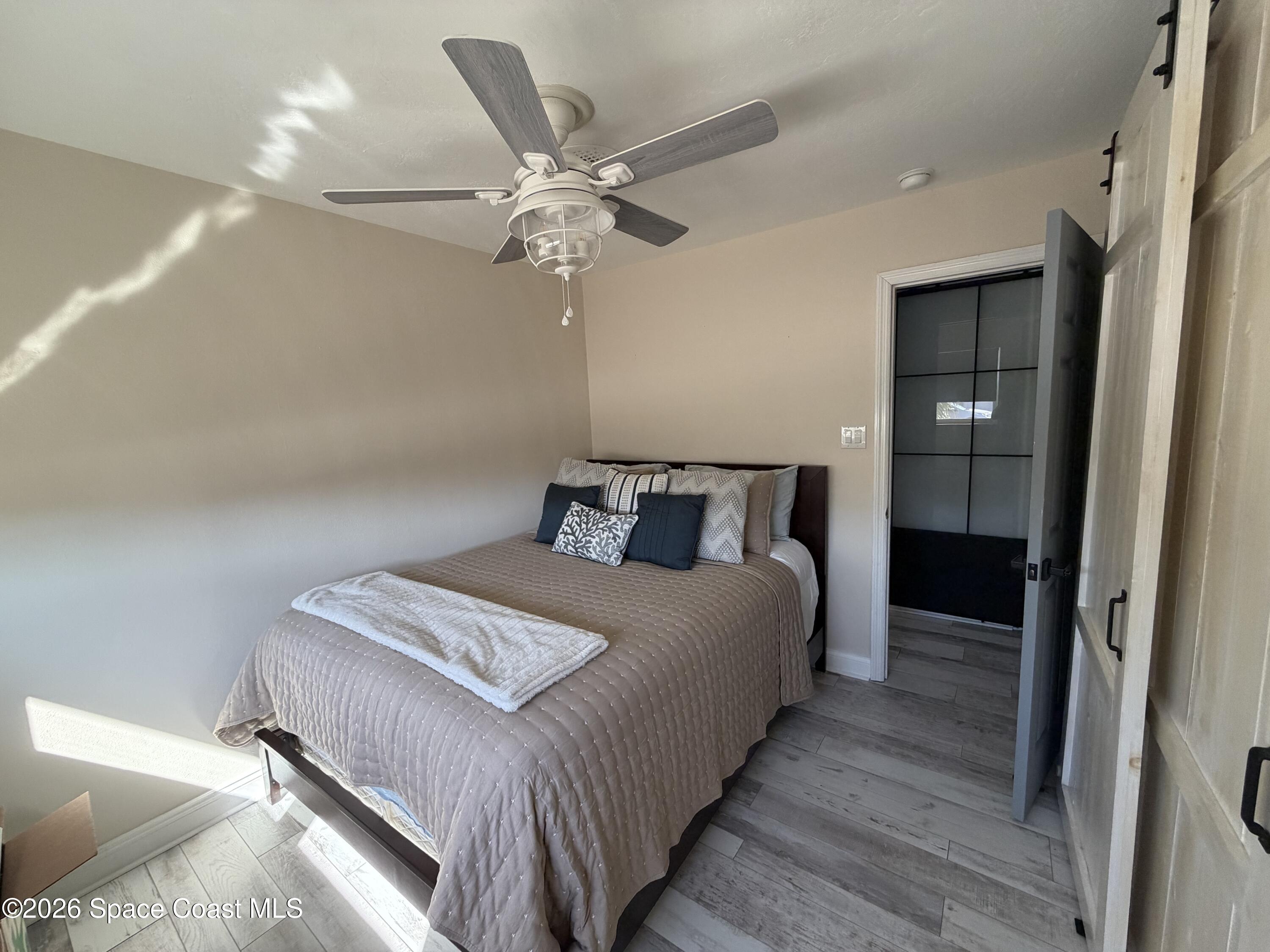 209 Southeast 3rd Street Satellite Beach, FL 32937 - Photo 11 of 25 a bedroom with bed and wooden floor