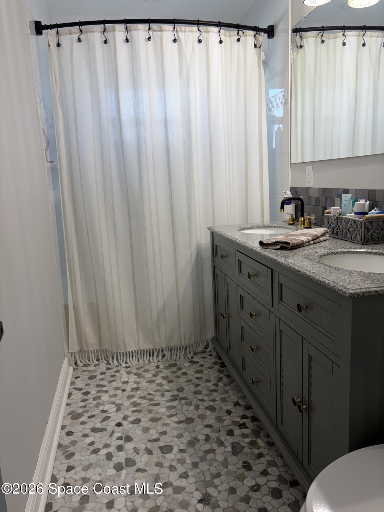 209 Southeast 3rd Street Satellite Beach, FL 32937 - Photo 12 of 25 a bathroom with a granite countertop sink and a mirror