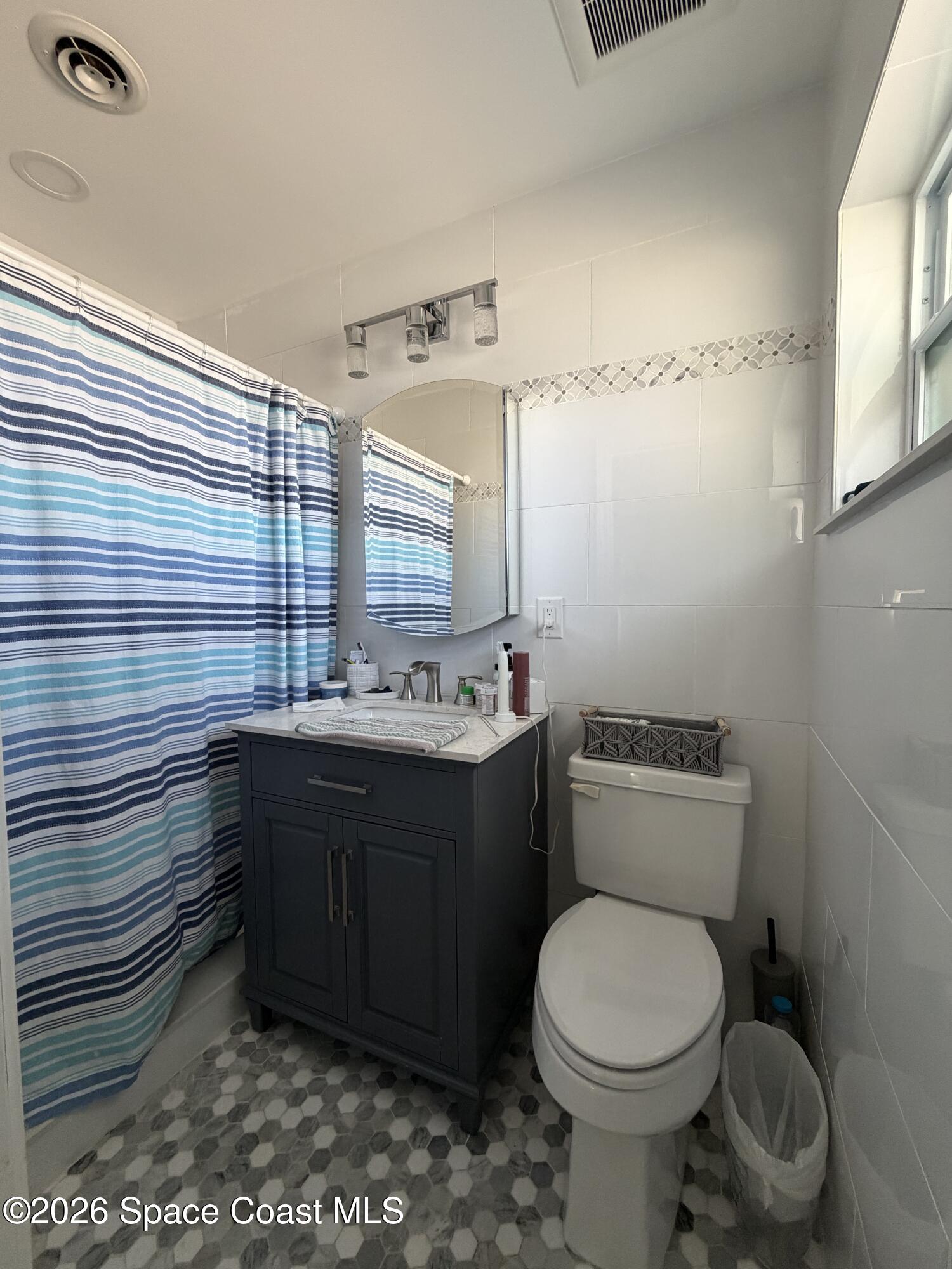 209 Southeast 3rd Street Satellite Beach, FL 32937 - Photo 13 of 25 a bathroom with a granite countertop toilet sink and mirror