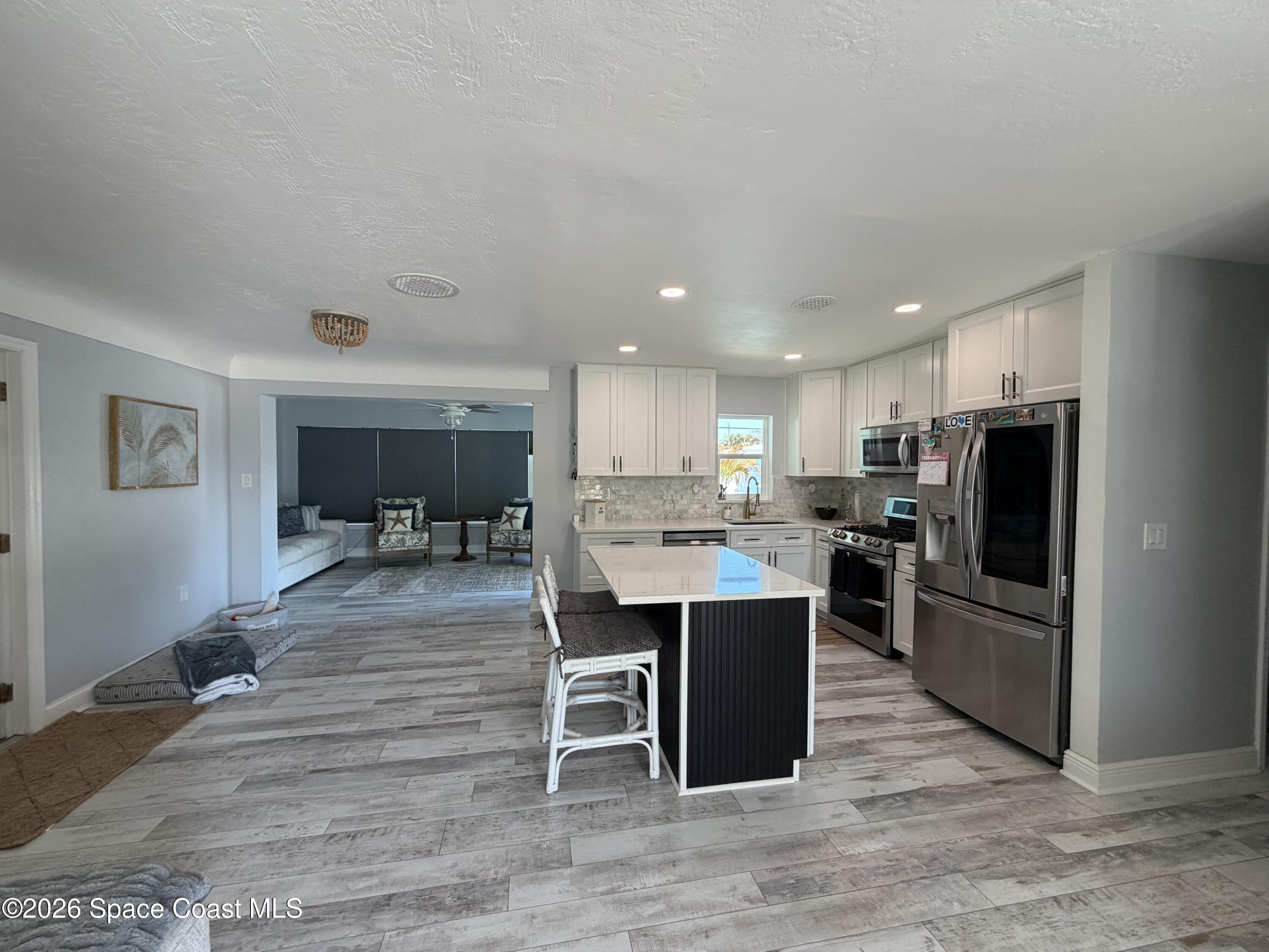 209 Southeast 3rd Street Satellite Beach, FL 32937 - Photo 5 of 25 a kitchen with kitchen island a sink appliances and cabinets