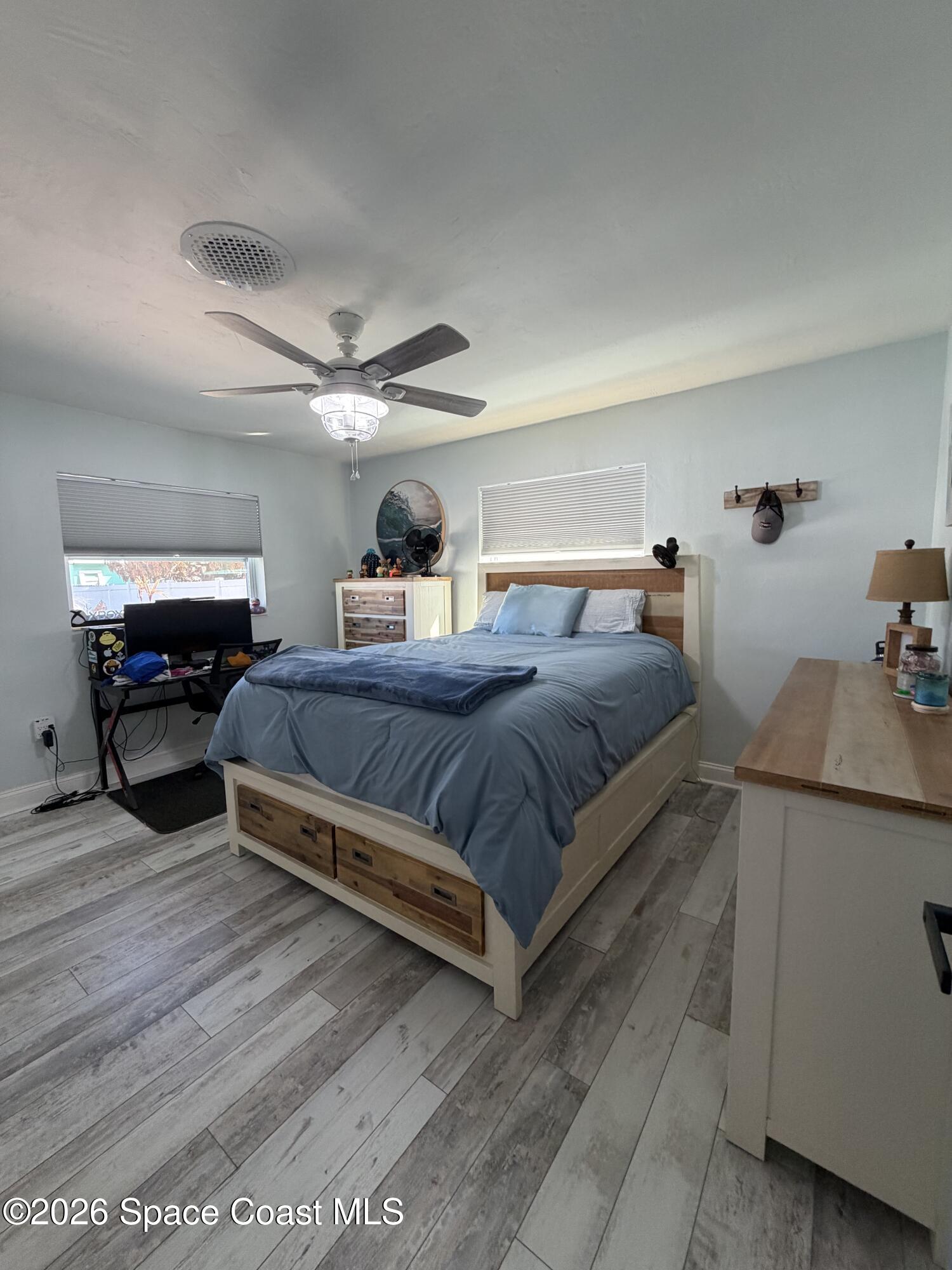 209 Southeast 3rd Street Satellite Beach, FL 32937 - Photo 10 of 25 a bedroom with a bed and dresser with wooden floor