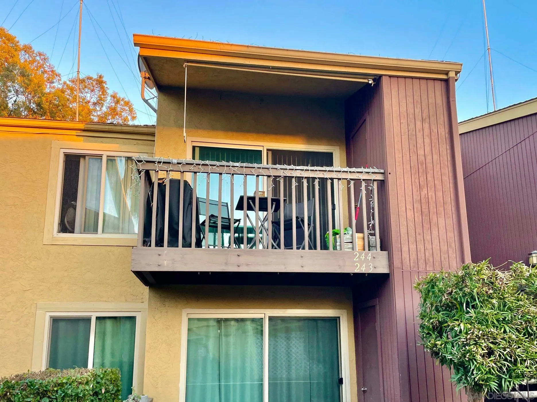 5970 Rancho Mission Road, Unit 244 San Diego, CA 92108 - Photo 18 of 21 a view of a house with a small yard and wooden floor and fence