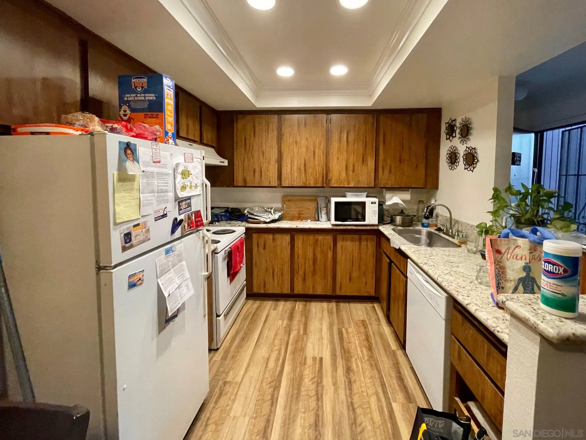 5970 Rancho Mission Road, Unit 244 San Diego, CA 92108 - Photo 7 of 21 a kitchen with kitchen island a white counter top space a sink and a refrigerator