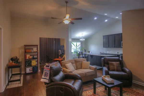 a living room with furniture a ceiling fan and a window