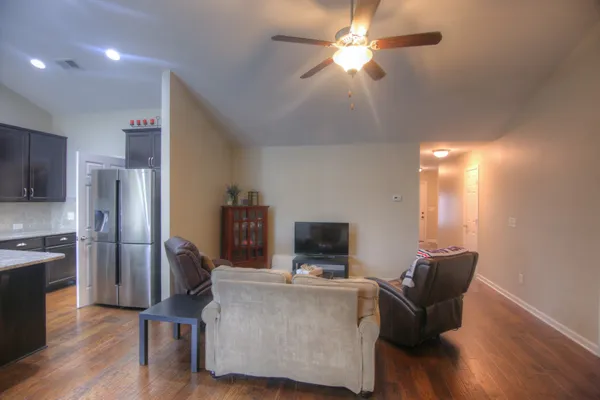 a living room with furniture and a kitchen view