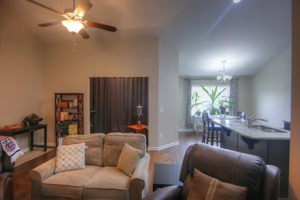 a living room with furniture a ceiling fan and a window