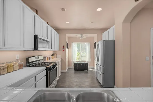 a kitchen with stainless steel appliances a refrigerator a stove a sink and a cabinets