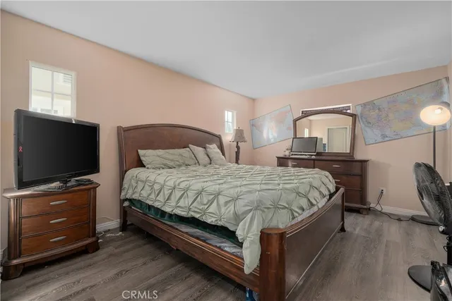 a spacious bedroom with a bed and a flat screen tv