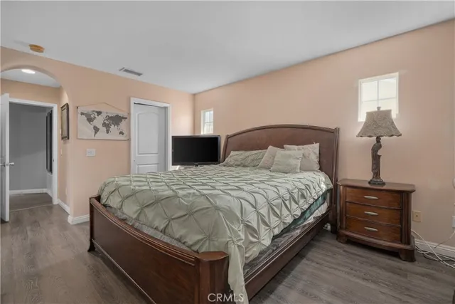 a spacious bedroom with a bed and a lamp