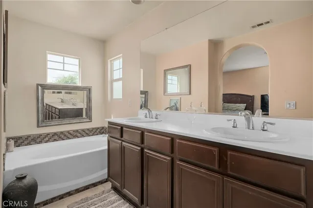 a bathroom with a tub sink and mirror