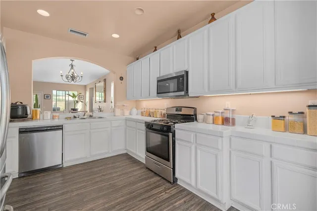 a kitchen with granite countertop white cabinets and white appliances