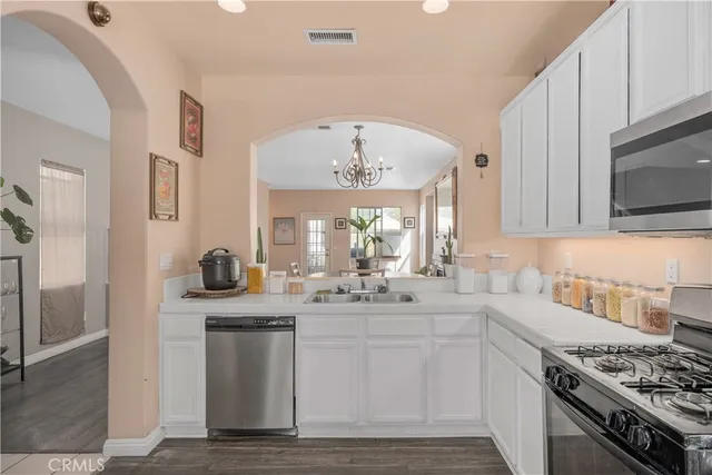 a kitchen with stainless steel appliances granite countertop a sink stove and cabinets