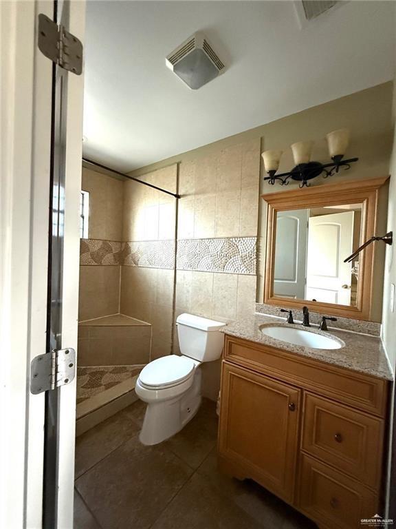 5501 North Moorefield Road Mission, TX 78574 - Photo 6 of 11 a bathroom with a double vanity sink toilet mirror and shower