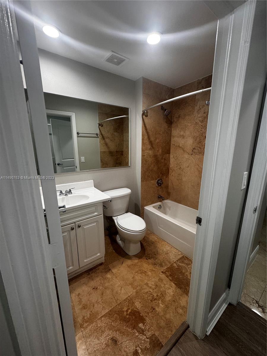 a bathroom with a sink toilet vanity and shower