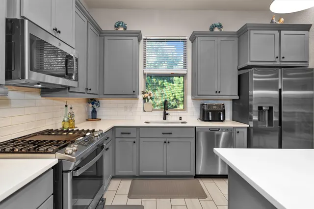 a view of a kitchen with kitchen island a counter top space appliances and a chandelier